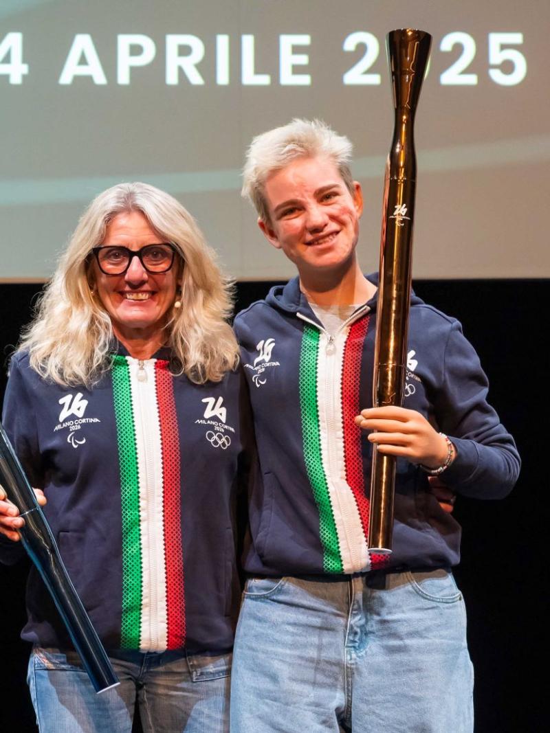 Bebe Vio and Stefania Belmond are holding the Milano Cortina 2026 torches during a presentation event. 