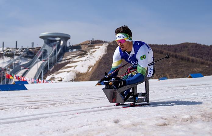 A male Paralympic sit-skier competes in Para cross-country skiing during Beijing 2022