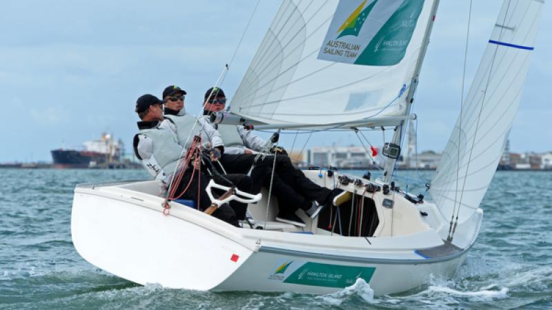 Three men in a boat sailing