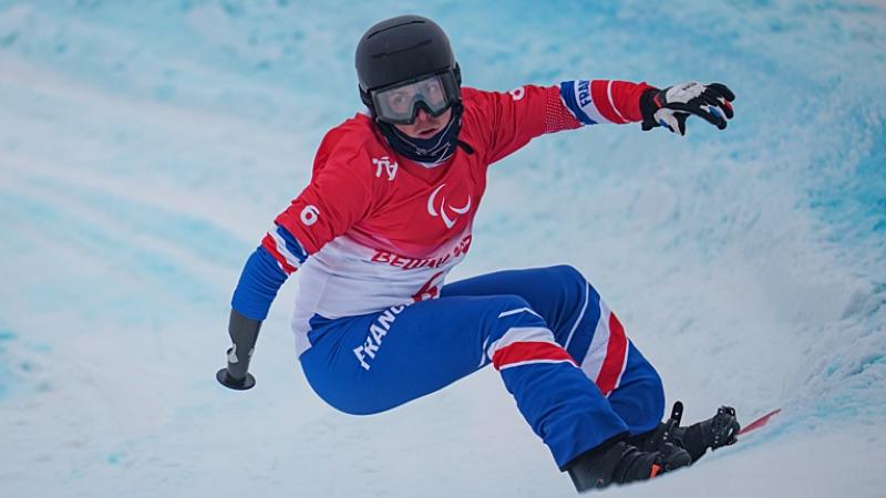 A male Para snowboard athlete competes at the Beijing 2022 Paralympic Winter Games