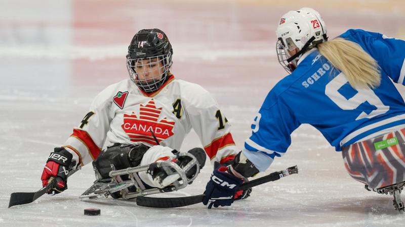 Two female Para ice hockey players in a game