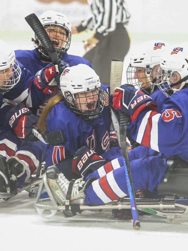 USA women's Para ice hockey team celebrating a goal on ice