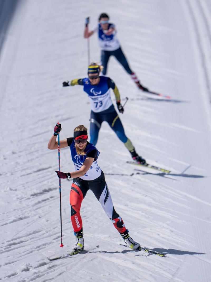 Three female cross-country skiers compete at Beijing 2022.