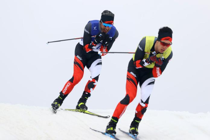 Two male Para cross-country skiing athletes in action