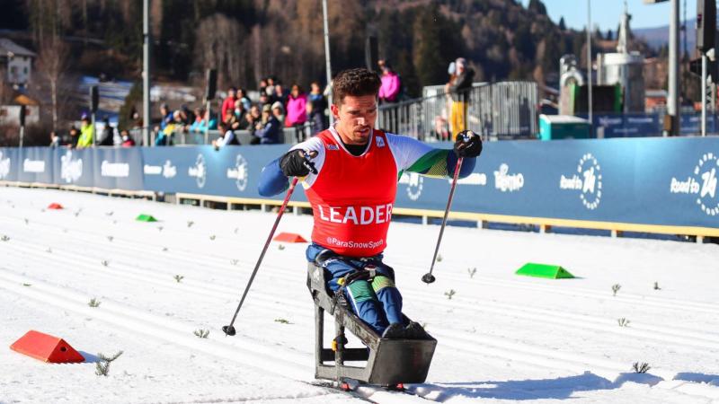 A male athlete is competing on a sit-ski