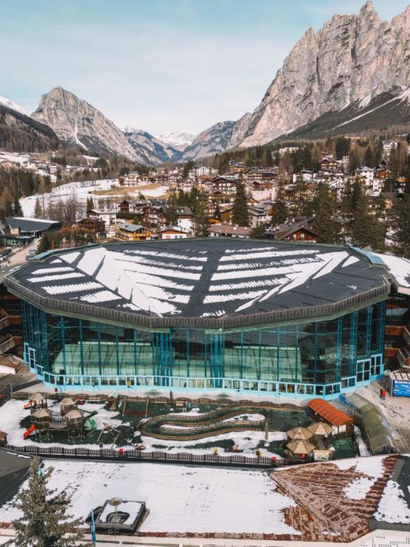 The Cortina Curling Olympic Stadium, located in front of the Dolomites
