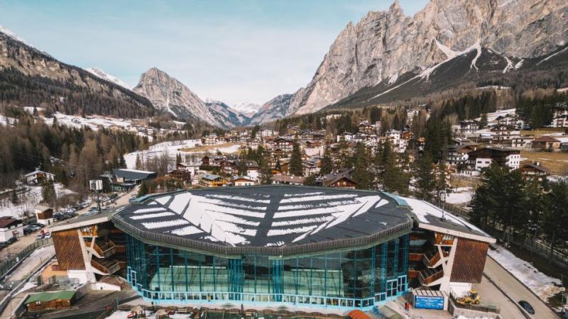 The Cortina Curling Olympic Stadium, located in front of the Dolomites