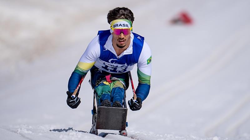 A male Paralympic sit-skier competes in Para cross-country skiing during Beijing 2022