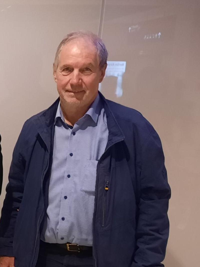 Four officials wearing formal attire pose for a photograph