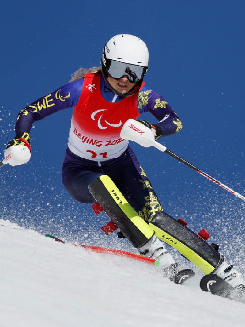 A female Para alpine skiing athlete competes at the Beijing 2022 Paralympics.