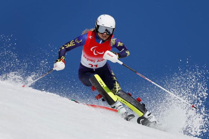 A female Para alpine skiing athlete competes at the Beijing 2022 Paralympics.