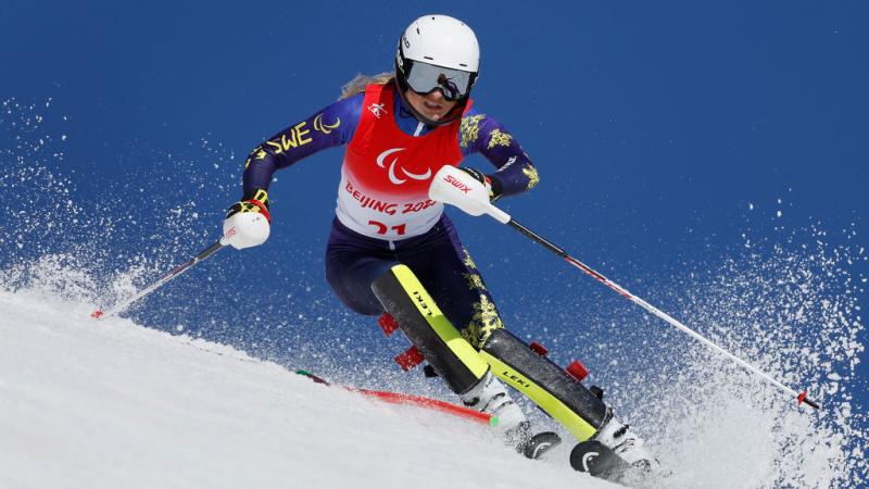 A female Para alpine skiing athlete competes at the Beijing 2022 Paralympics.
