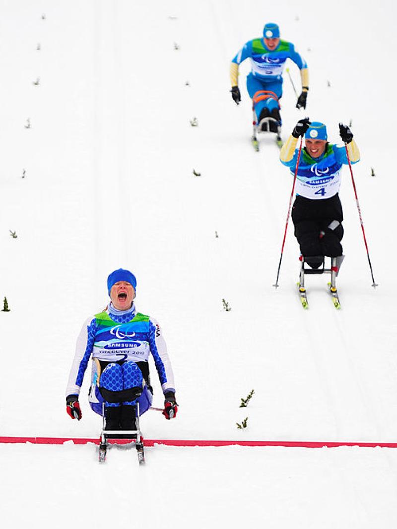 Four Para cross-country sit-skiers in action. Francesca Porcellato, who is in the centre of the image, reacts after crossing the red line