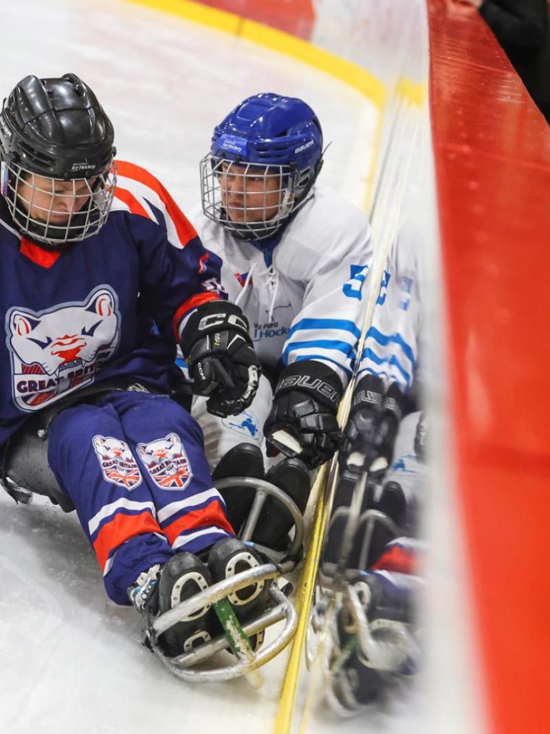 A Team GB and a Team World female player in a Para ice hockey game