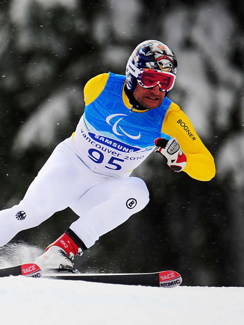 A male Para alpine skier is in competition.