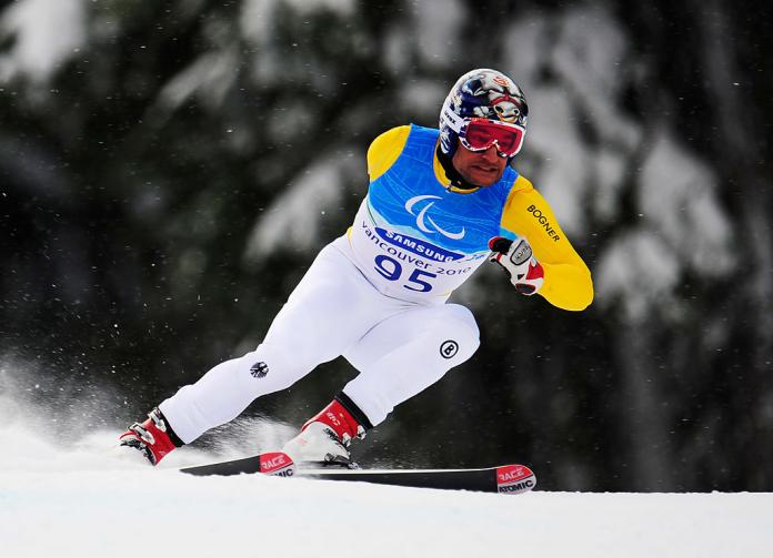 A male Para alpine skier is in competition.