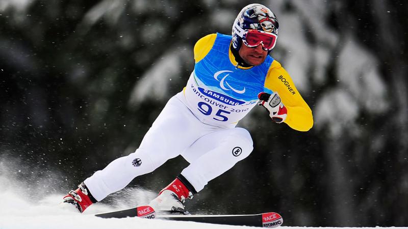 A male Para alpine skier is in competition.