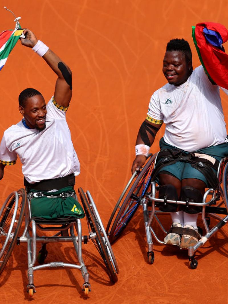 Donald Ramphadi and Lucas Sithole wave South African flags on court