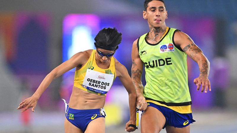 A female sprinter and her guide in a race