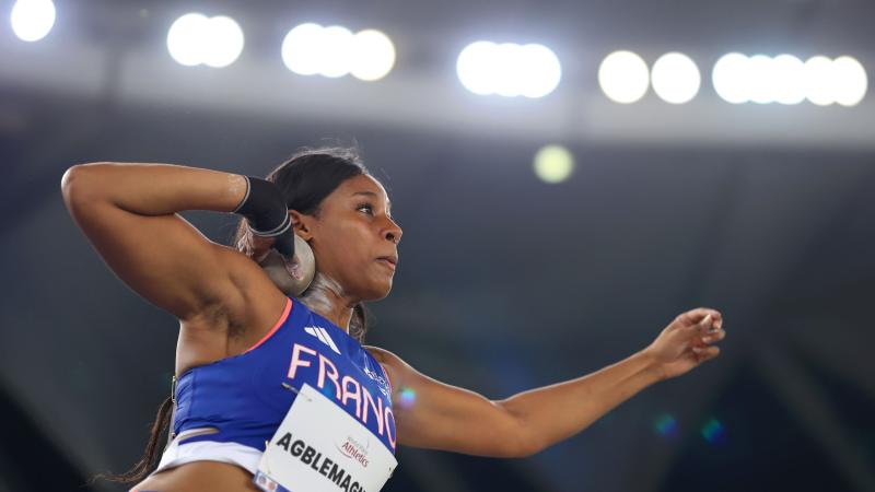 A female athlete competing in the shot put