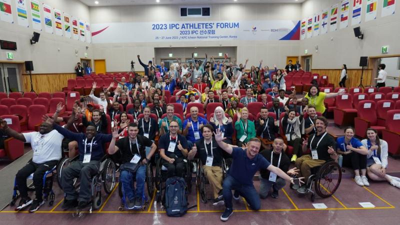 About 60 people pose in an auditorium at the third IPC Athletes Forum in Korea.