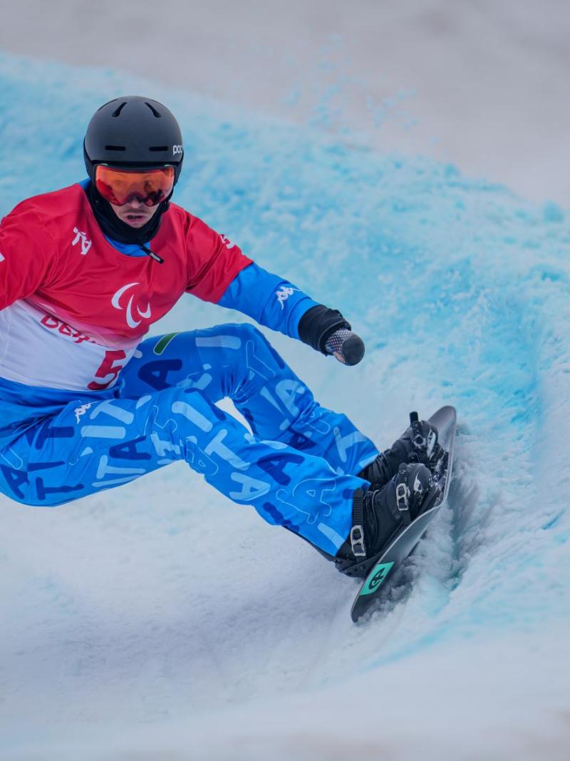 A male snowboarder competes at Beijing 2022 Paralympic Games.