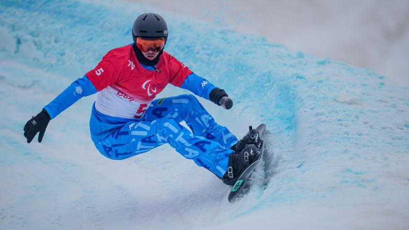 A male snowboarder competes at Beijing 2022 Paralympic Games.