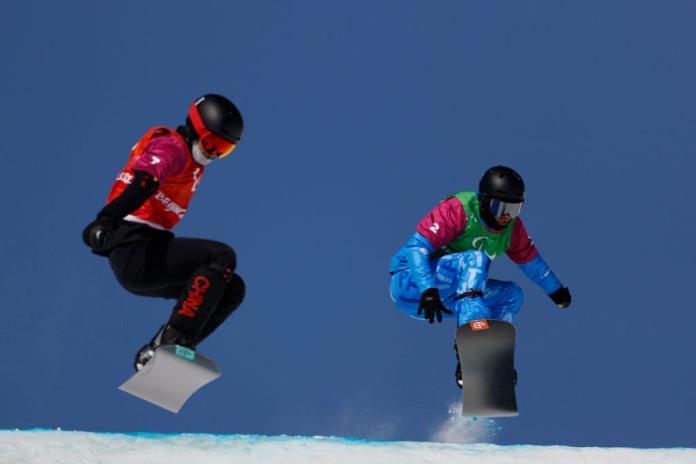 Jacopo Luchini jumping over a hill on his snowboard during the Beijing 2022 Paralympic Winter Games.
