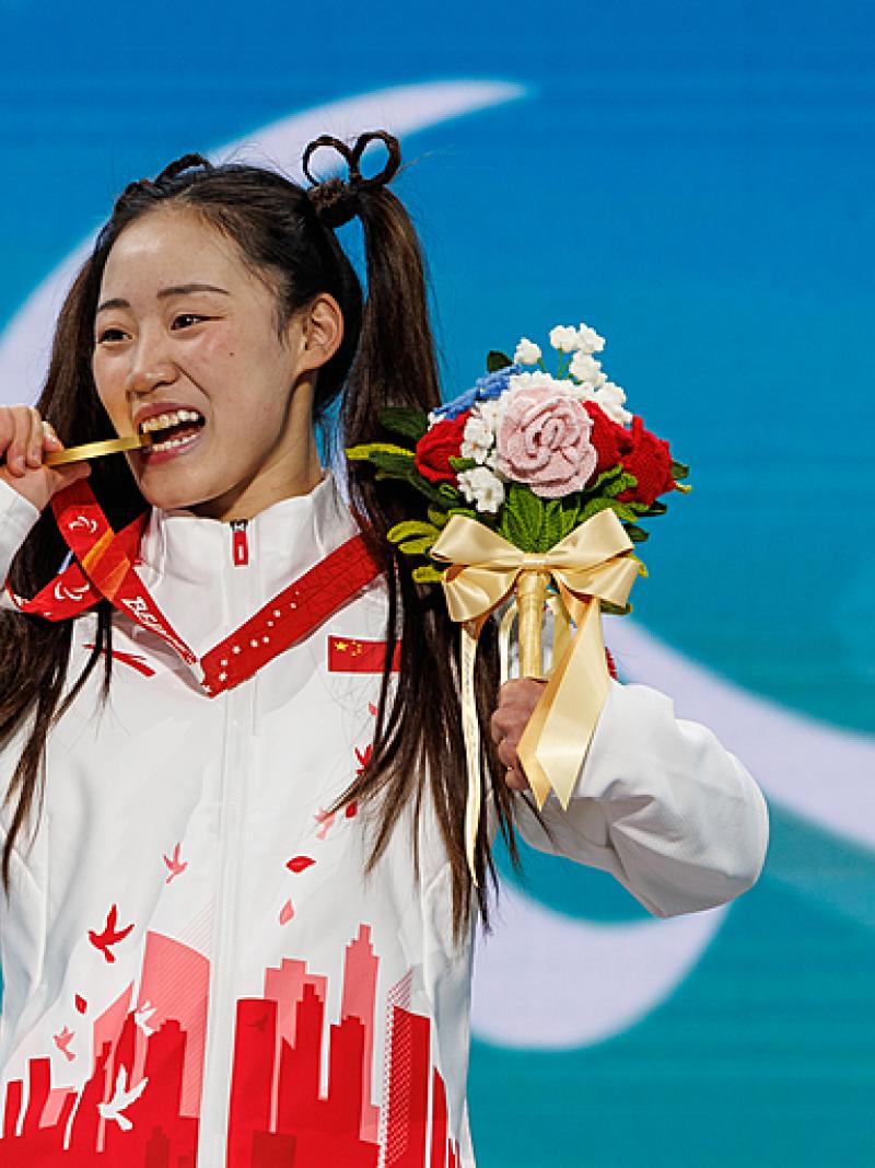 Menqiu Zhang bites her gold medal