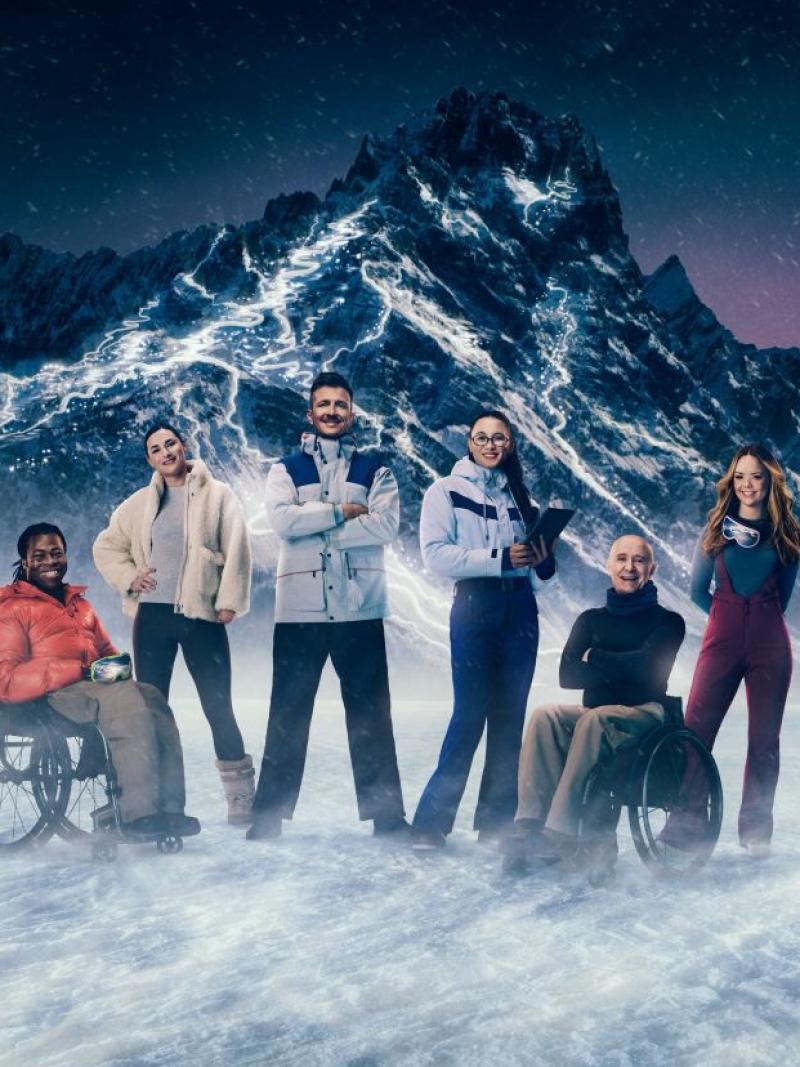 Seven people stand in front of a snowy mountain, which will host the Milano Cortina 2026 Paralympics, 