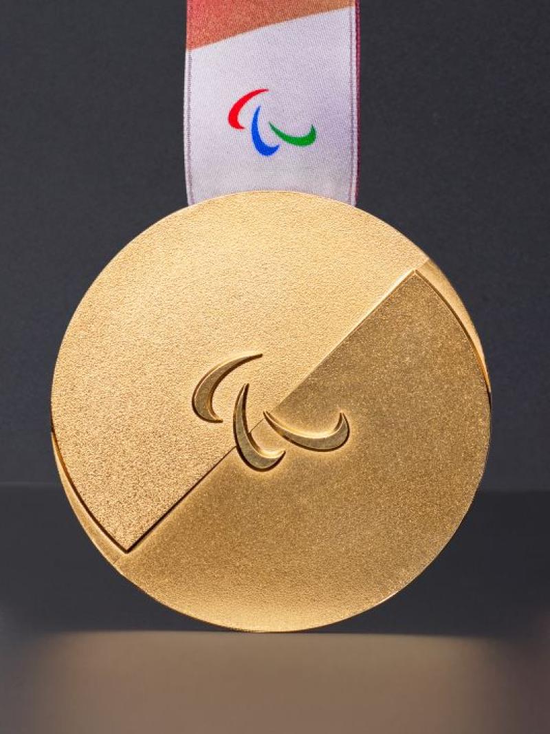 Photo of silver, gold and bronze medals - the medals have the Agitos symbol in the centre and have red ribbons. The official Milano Cortina 2026 Paralympic Winter Games medals, showcasing Italian craftsmanship