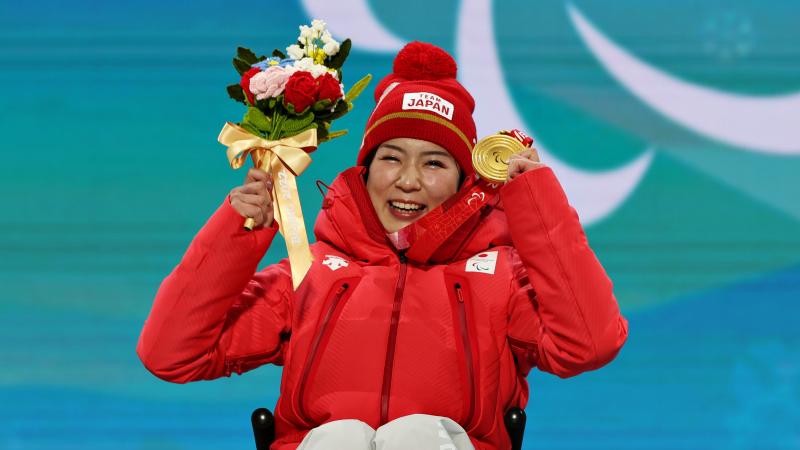 Japanese sit-skier Momoka Muraoka celebrates with her gold medal 