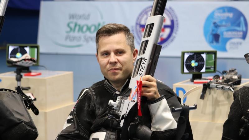 A shooting athlete with his rifle in a competition