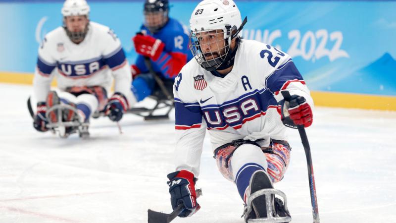 A male Para ice hockey player is in action - he is about to shoot a hockey puck
