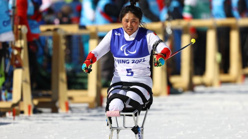 A female sit-skier is competing in Para cross-country skiing at the Beijing 2022 Paralympics