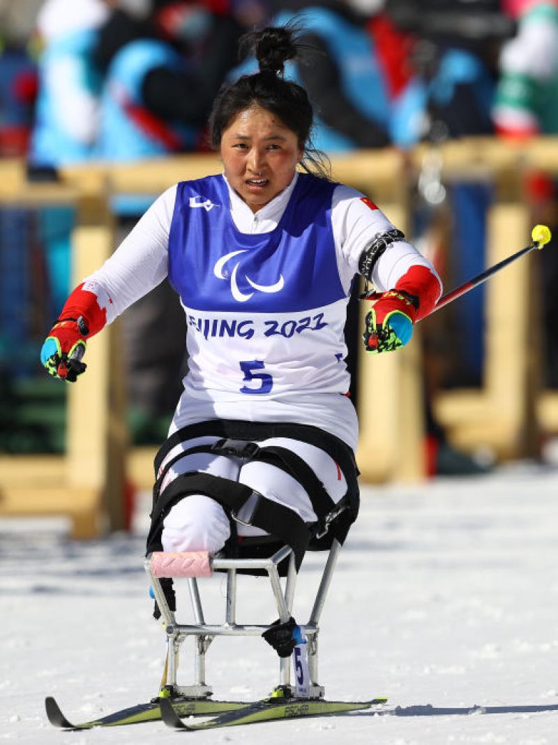 A female sit-skier is competing in Para cross-country skiing at the Beijing 2022 Paralympics