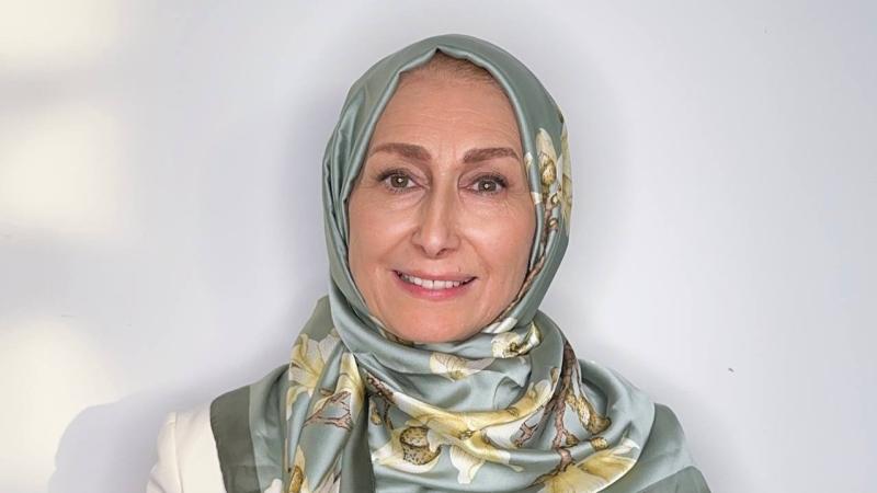 Sima Limouchi smiling in front of a white wall