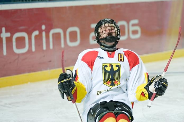 A male Para ice hockey player wearing Germany's uniform screams during a match at the Torino 2006 Paralympics