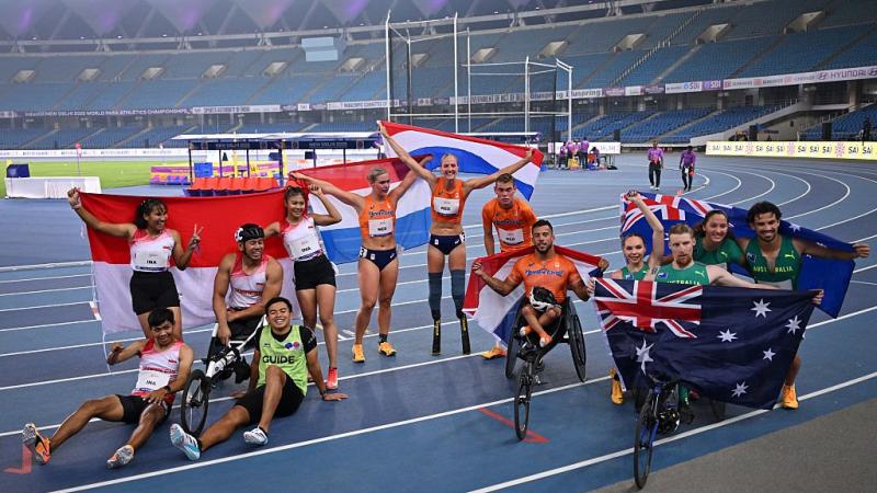 Athletes celebrate with their country flags on finish line 