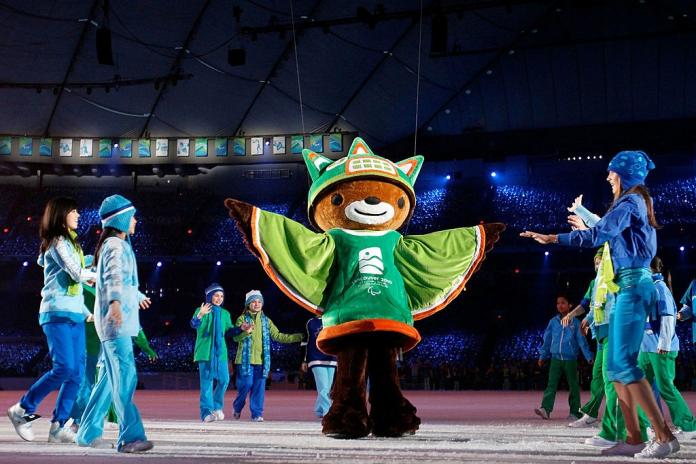 A mascot of the Vancouver 2010 Paralympic Mascot on stage, with performers around it.