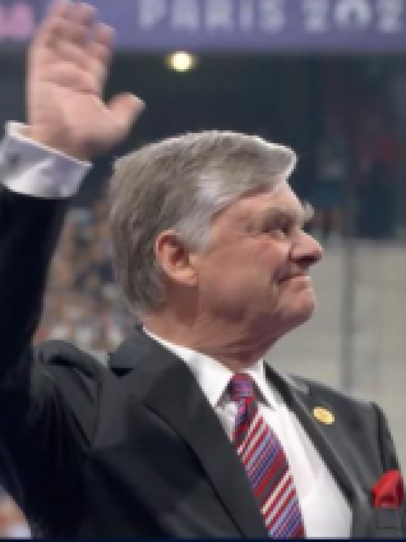 Dr Carl Axel Bolsinger is waving in a stadium 